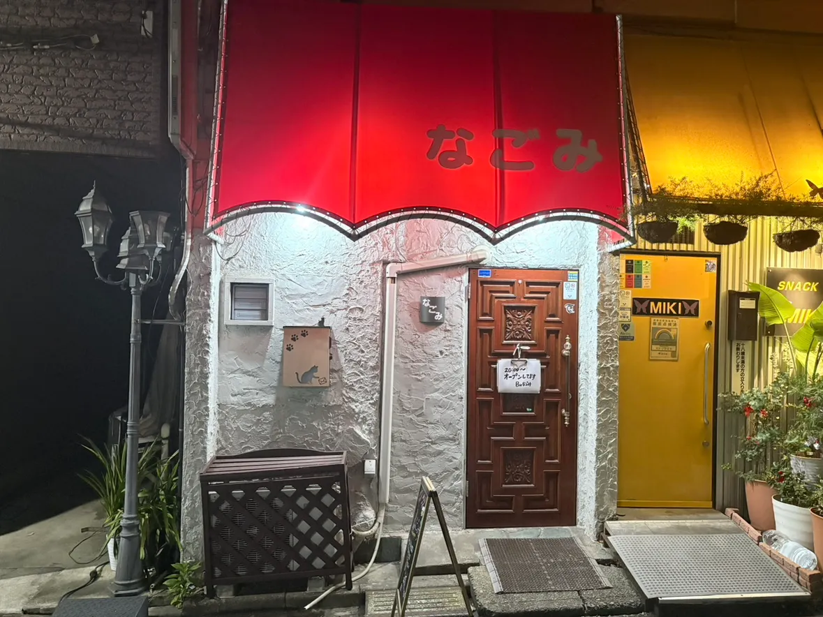 赤い庇と木の扉が目印のBarなごみ外観